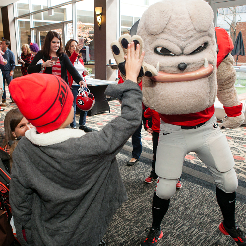 Hairy Dawg high-fiving kid at UGA Hotel